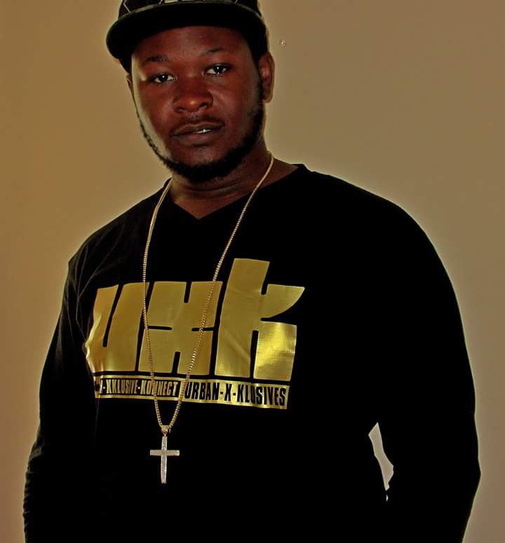 Trav wearing the original UXK logo longsleeve with a cross necklace